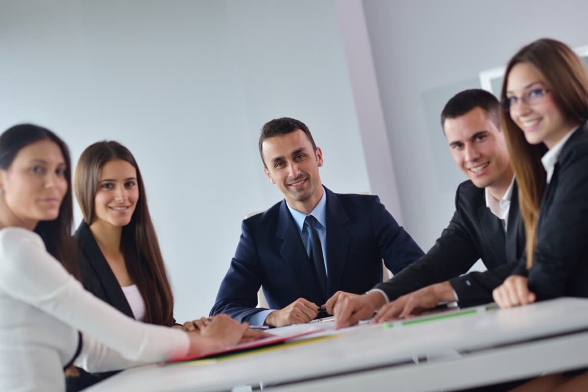 Advisers seated around a boardroom table with documents in front of them